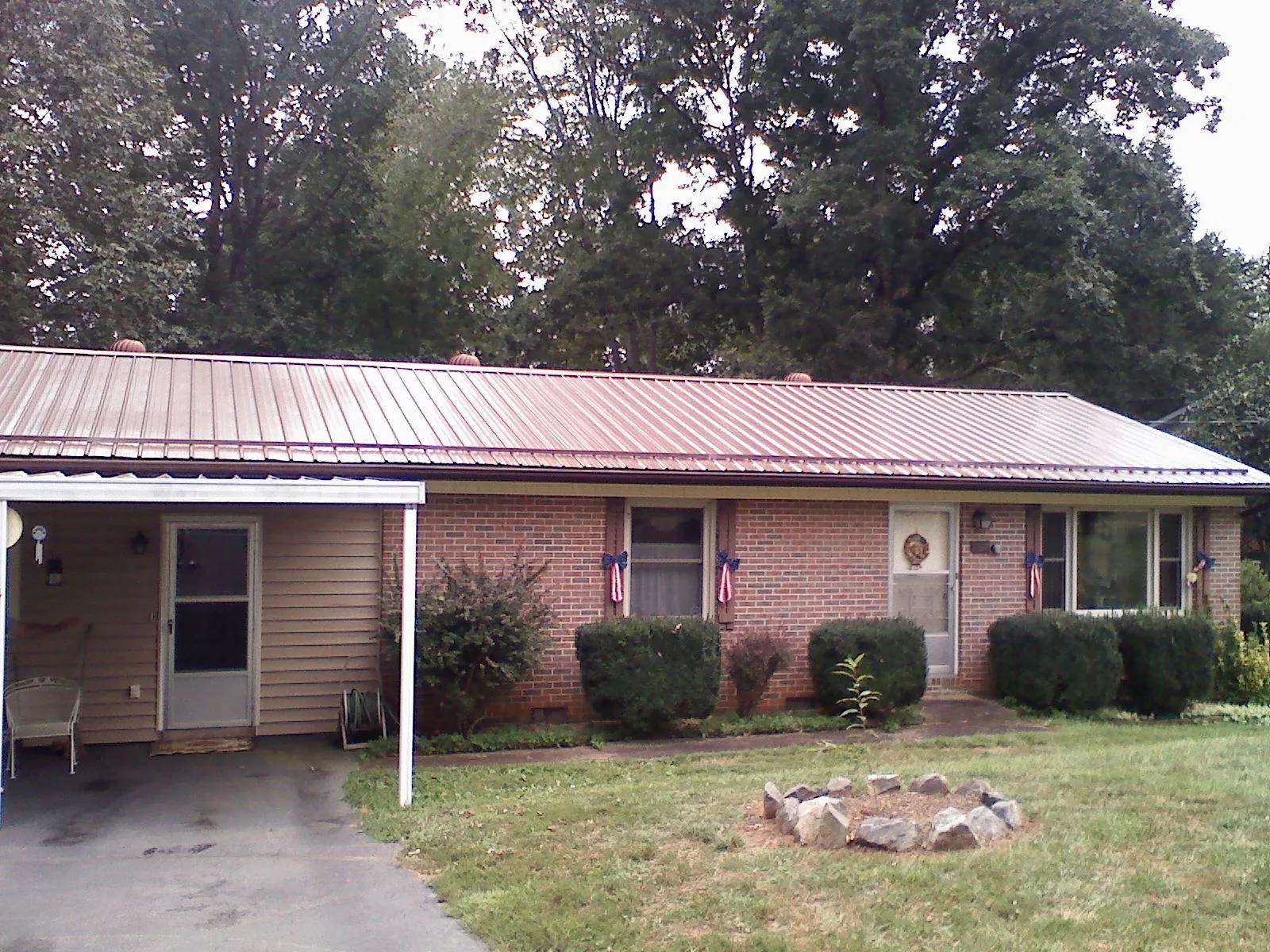 Bronze metal roof and carport on a brick ranch home — Roof Repair work by our crew in Tavernier